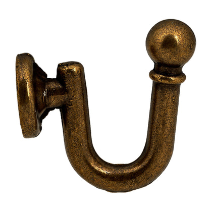 Wall mounted curtain tie back hook. Designed as metal ball end at top of a U-shaped metal hook